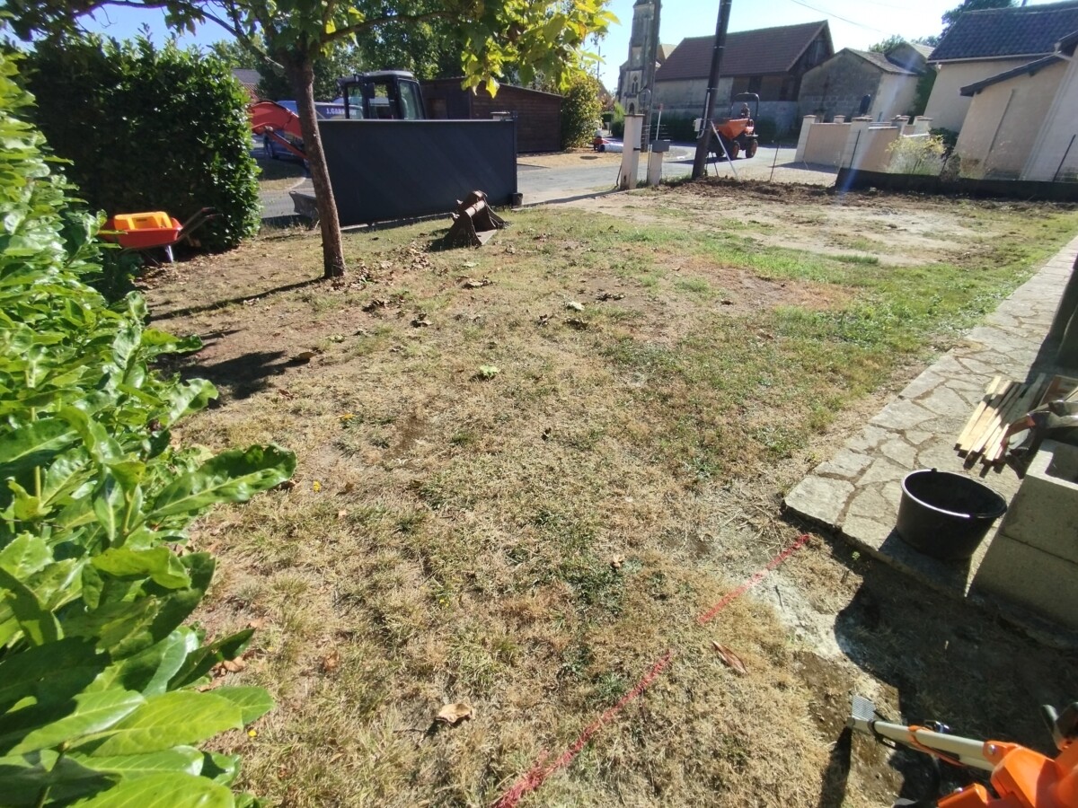 Vue la cour cour en terre battue d'une maison individuelle. Avant travaux.
