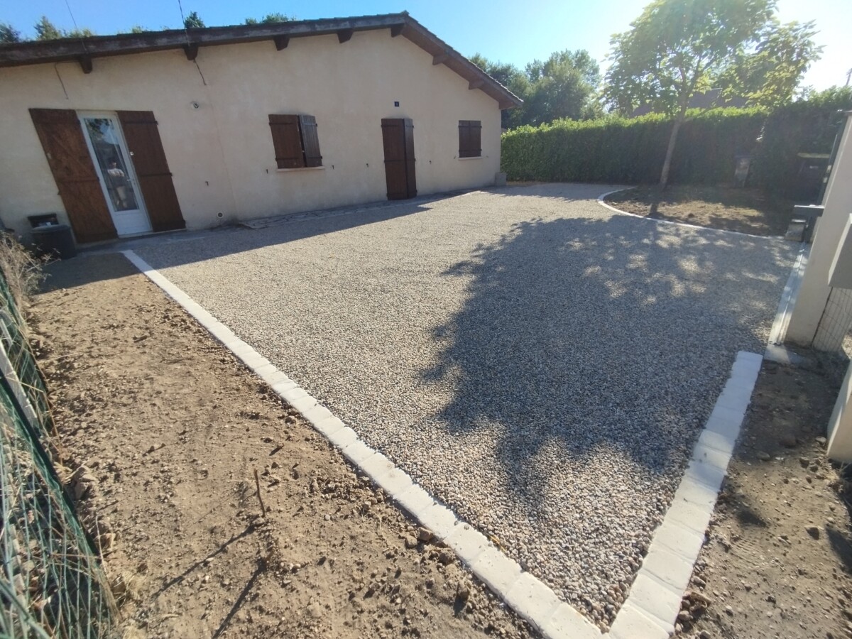 Vue de la cour après travaux. Cours en gravillons et bordure pavée.
