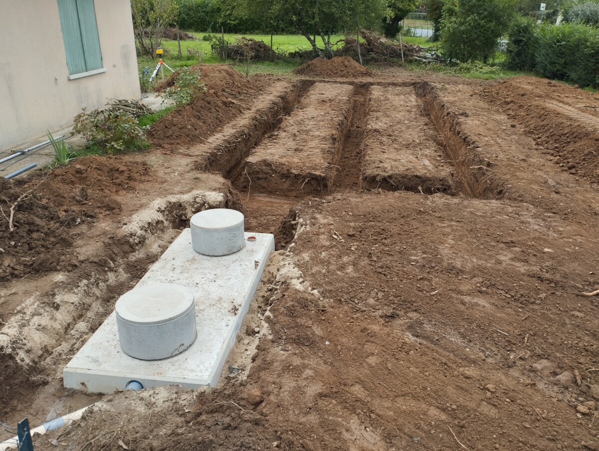 Vue de la fosse toutes eaux en béton et tranchées pour la mise en place des drains d'épandage .