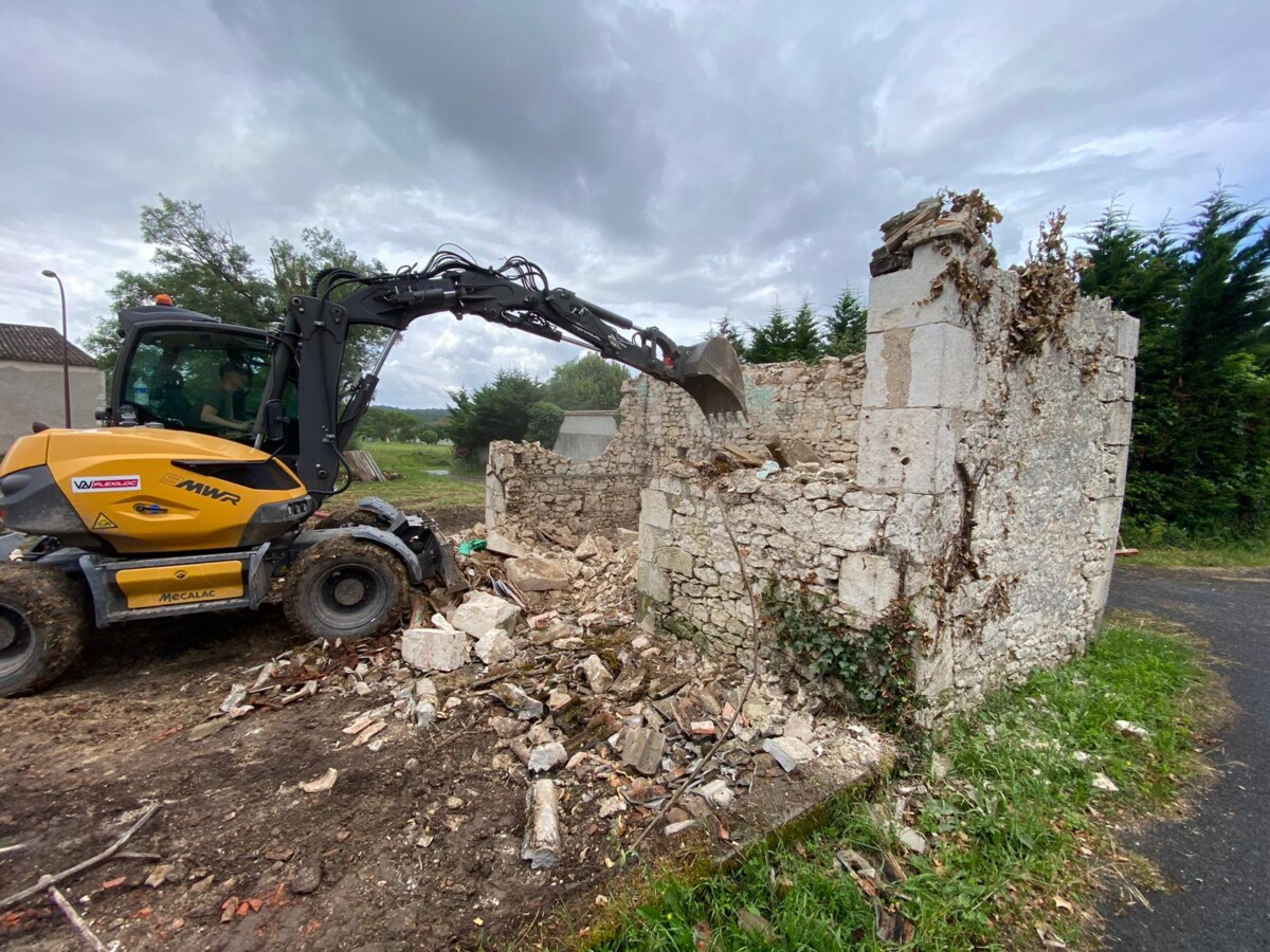 Pelle mécanique utilisée pour la démolition d'une maison en ruine. 2éme étape : démolition des murs.