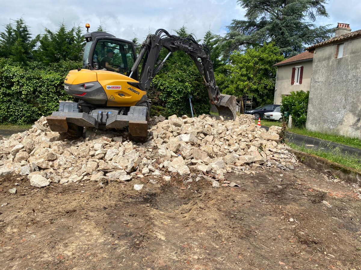 Pelle mécanique utilisée pour la démolition d'une maison en ruine. 3éme étape : Rassemblement des gravats en vue de leur évacuation.